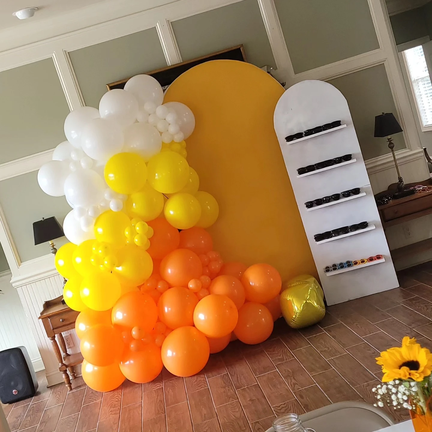 Yellow and orange balloon arch backdrop for a 'you are my sunshine' baby shower.