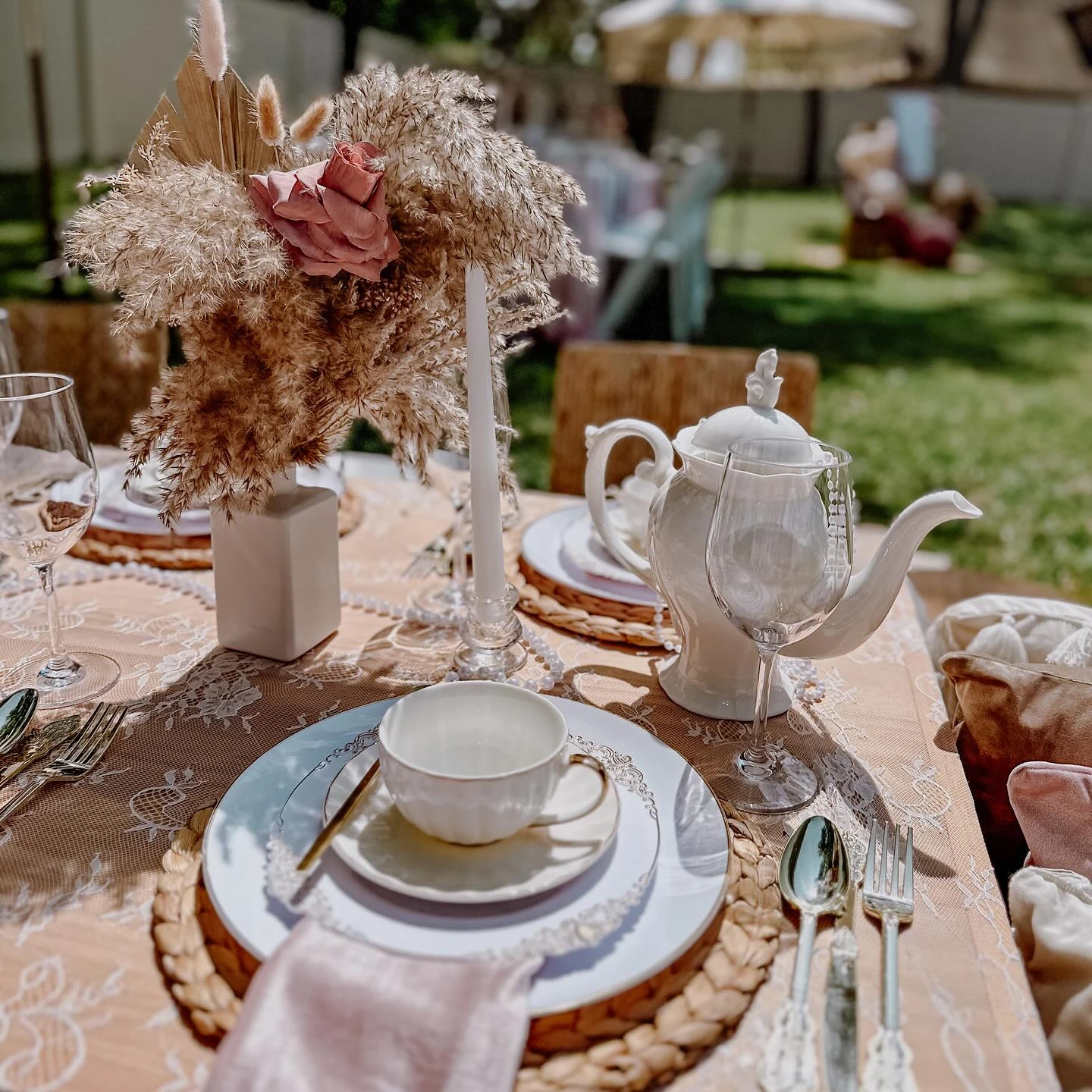 A single place setting for a boho tea party bridal shower with a dried floral centerpiece.