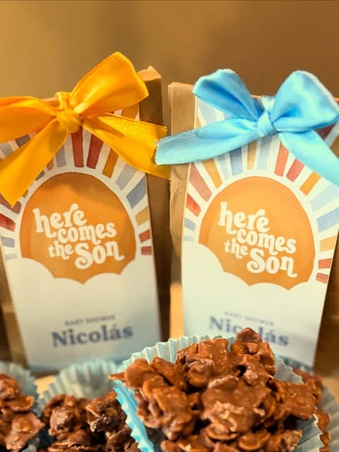 of 'Here comes the Son' baby shower favor bags with yellow and blue ribbons.