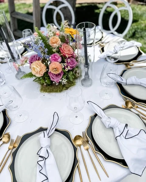 of a colorful spring floral centerpiece on a modern black and white tablescape.