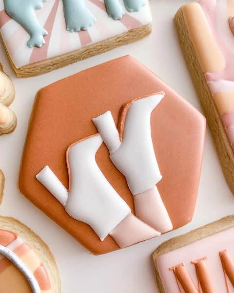A hexagonal cookie decorated with white 70s-style platform go-go boots.