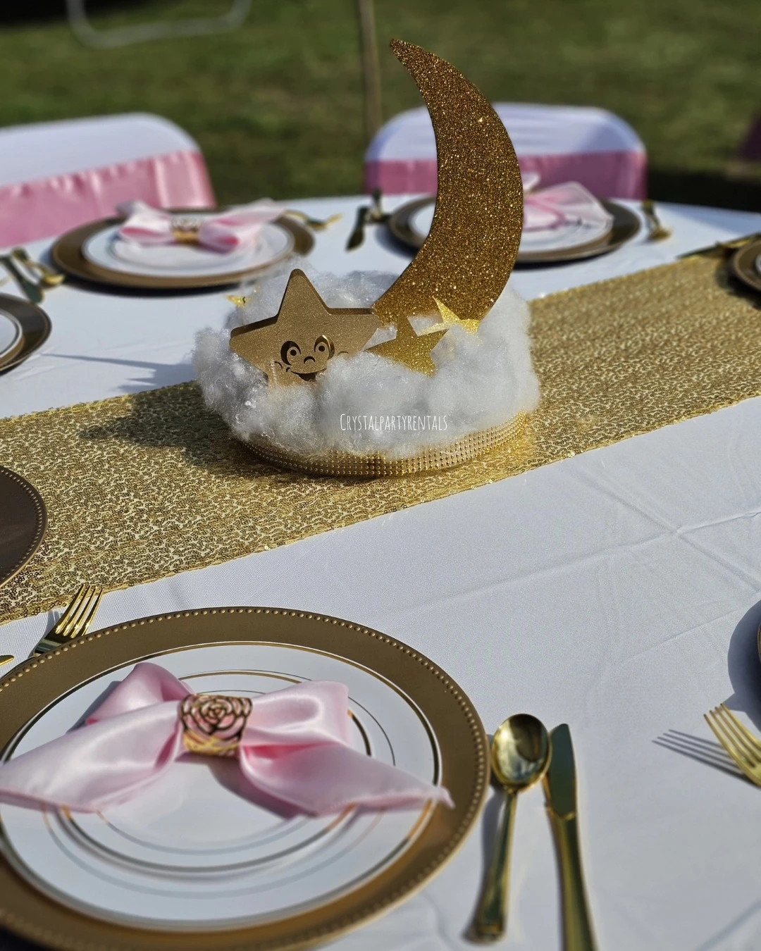 A 'Twinkle, Twinkle, Little Star' baby shower centerpiece with a gold glitter moon and star on a white fluffy cloud base.