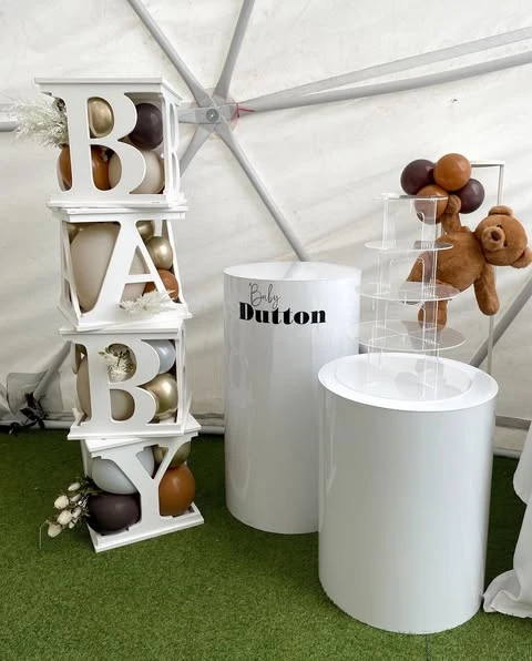 White 'BABY' blocks filled with brown and gold balloons for a teddy bear baby shower dessert station.