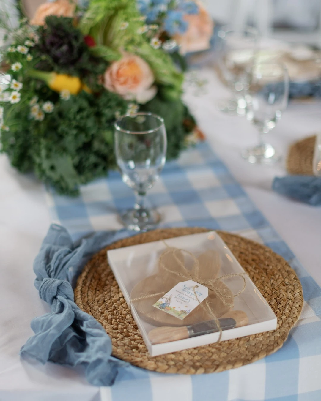 A paint-your-own rabbit cookie party favor on a woven placemat for a Peter Rabbit baby shower.