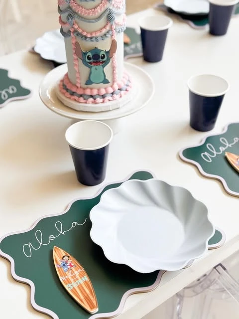Stitch party table setting with a green Aloha placemat and a Lilo surfboard accent.
