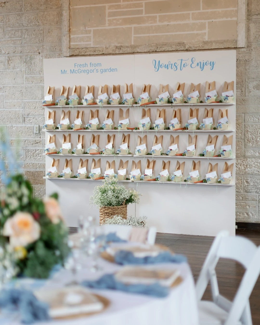 A large white favor display wall with shelves holding party favors for a Peter Rabbit baby shower.