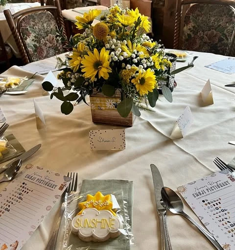 You are my sunshine baby shower table setting with a yellow floral centerpiece and cookie favors.