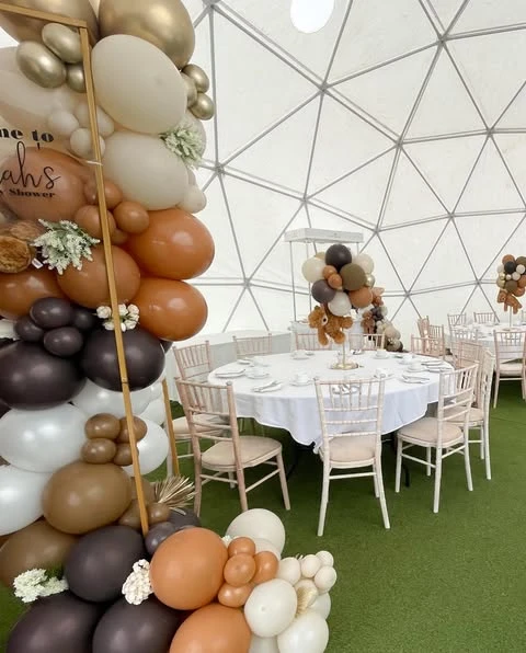 Overall view of a 'We Can Bearly Wait' baby shower in a dome tent, showing cohesive table centerpieces and balloon decor.