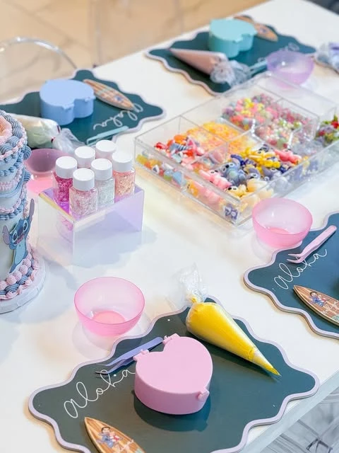 A Stitch-themed party activity station with craft and decorating supplies.
