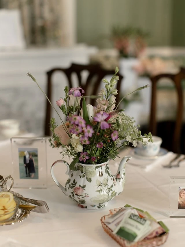 Floral teapot used as a centerpiece for a tea party bridal shower table.
