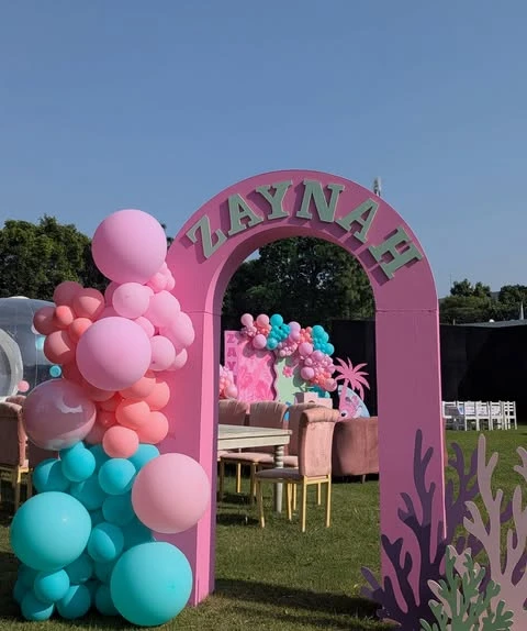 A pink entrance arch with a balloon garland for a Stitch themed birthday party.