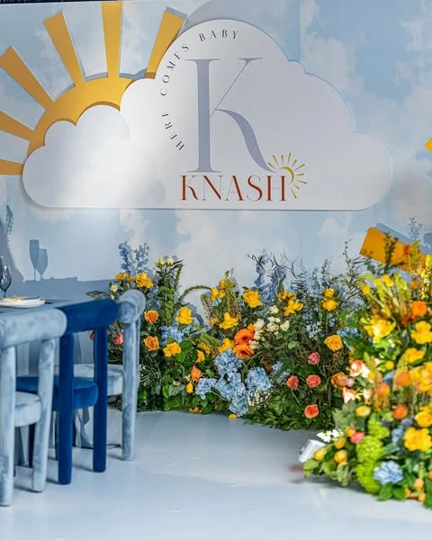 Custom 'Here Comes the Sun' baby shower backdrop with a sun and cloud motif and personalized text.