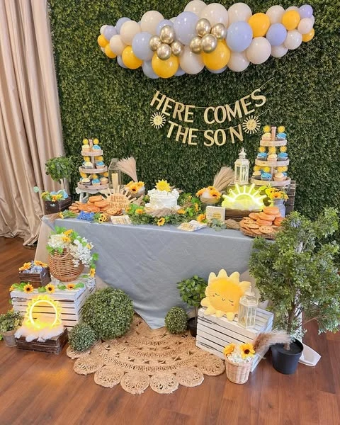 Here Comes the Son baby shower dessert table with a boxwood backdrop and balloon garland.
