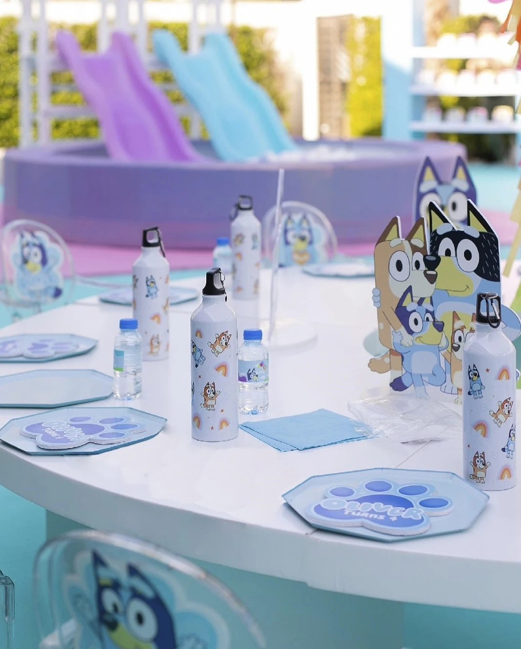 A Bluey-themed kids' party table with paw print plates and a character centerpiece.