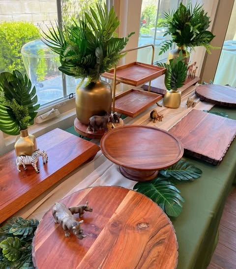of a jungle-themed food station highlighting how small rhino and zebra figurines are used as decor next to wooden serving platters.