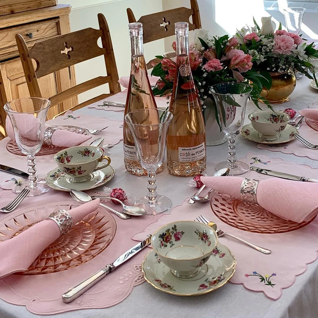 of a tea party place setting with a floral teacup and pink glass plate.