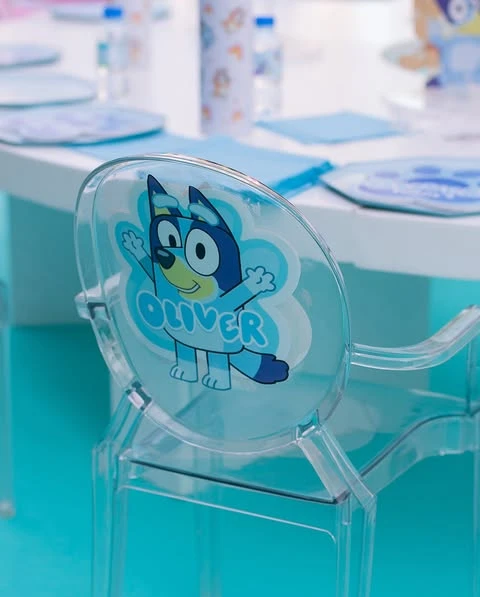 A personalized clear party chair with a Bluey character and a child's name.