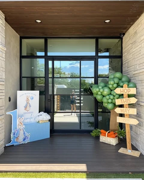 Full entrance display for a Peter Rabbit baby shower with a welcome station and a rustic directional sign.