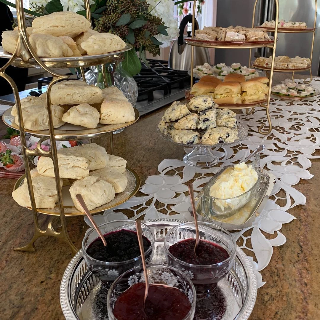 Tiered food stands filled with scones and finger sandwiches for a tea party.