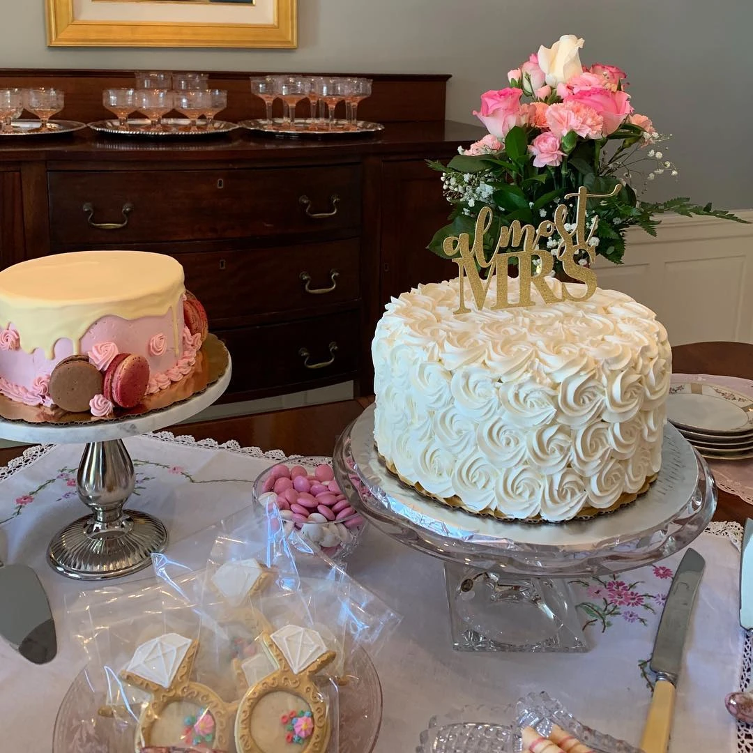 Bridal shower dessert table with two cakes, one with an 'Almost Mrs' topper.
