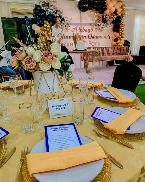 Overhead view of a retirement party table setting highlighting the gold and black color scheme.