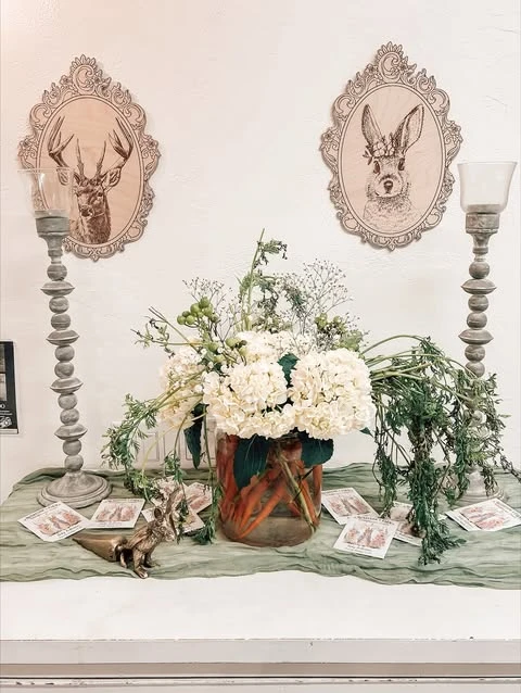 Peter Rabbit baby shower centerpiece with carrots in a vase and white flowers.