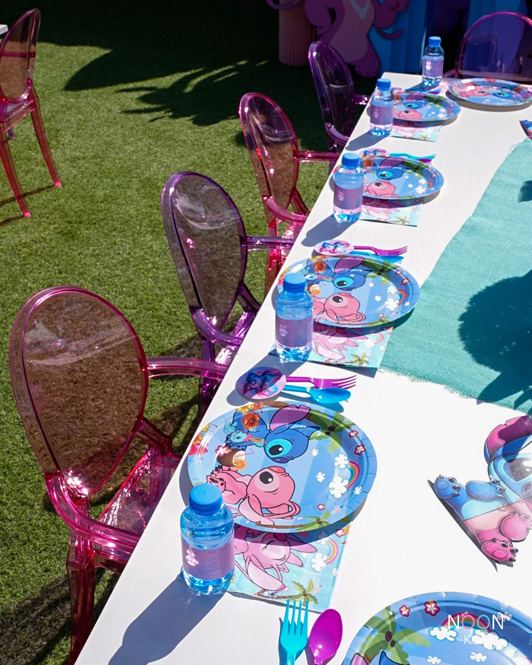 Stitch and Angel themed birthday party table setting with pink and purple translucent chairs.