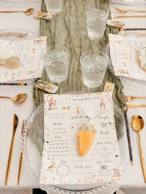 A of a Peter Rabbit baby shower place setting with a carrot cookie favor.