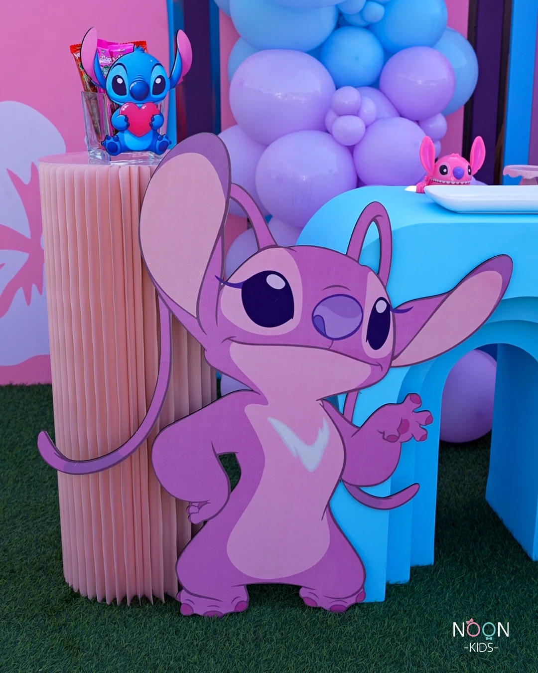 Large cardboard cutout of the character Angel next to a pink paper pedestal.