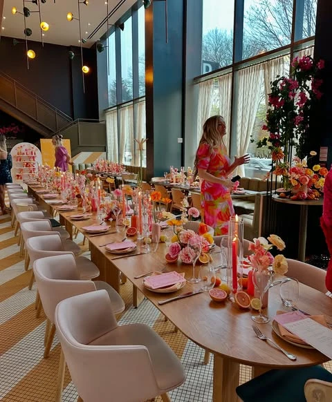 An overview of a spring bridal shower with a long table decorated with a citrus and floral theme.