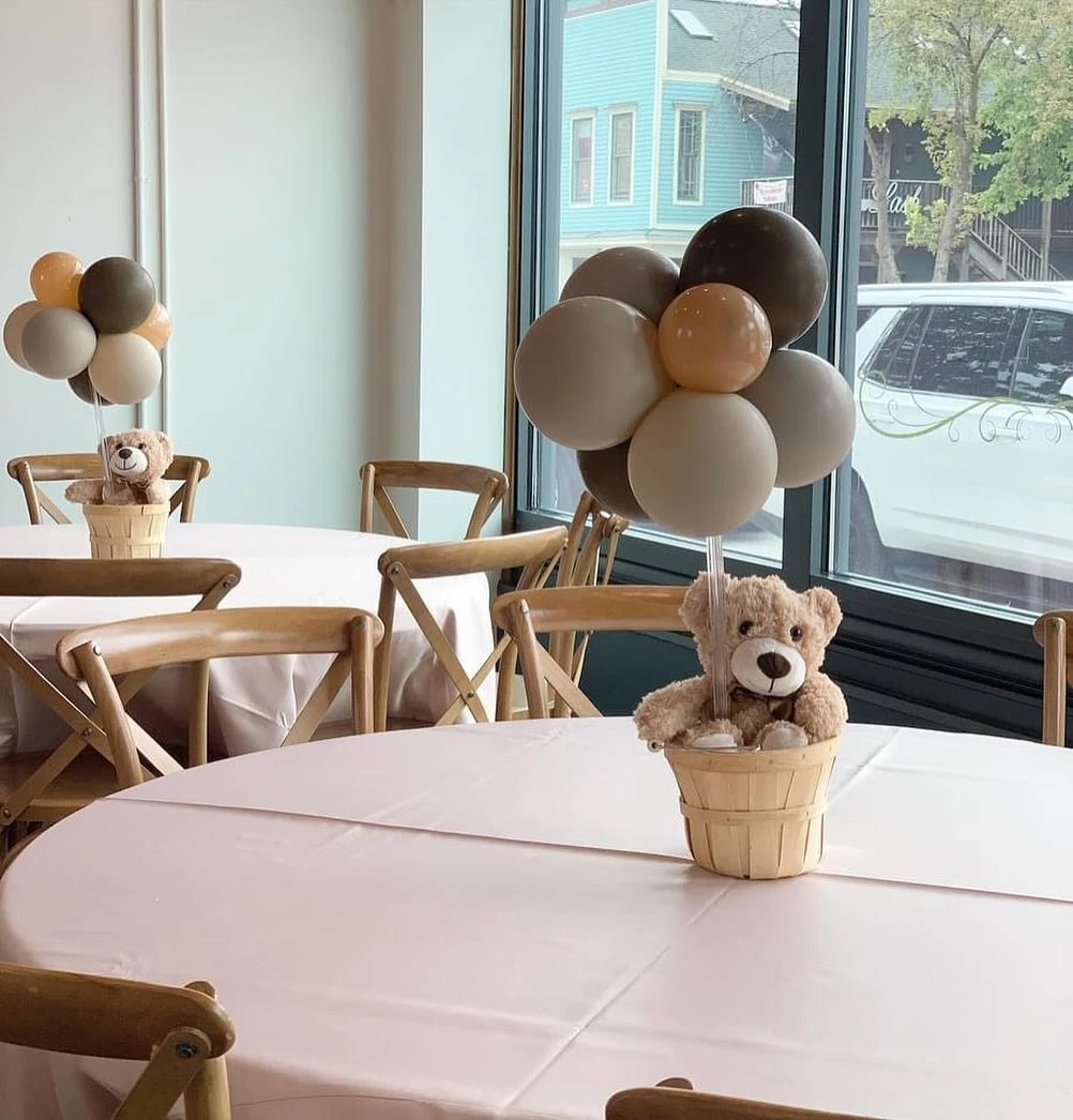 Teddy bear and balloon centerpiece on a baby shower guest table.