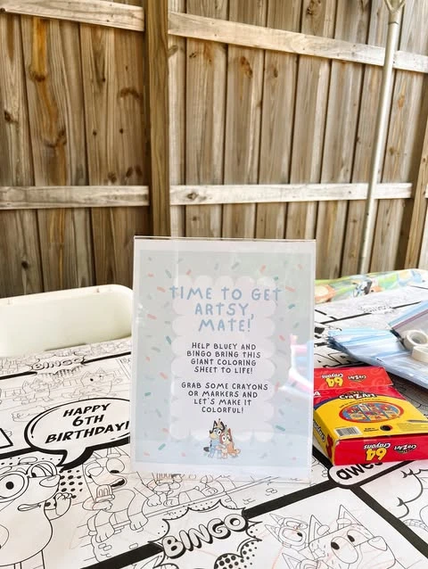 A Bluey-themed coloring station with a giant coloring sheet and boxes of crayons.