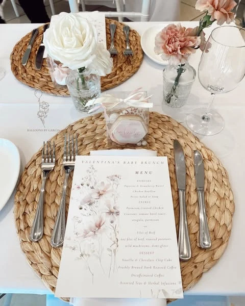 Place setting with a woven placemat and a menu featuring a delicate wildflower print.