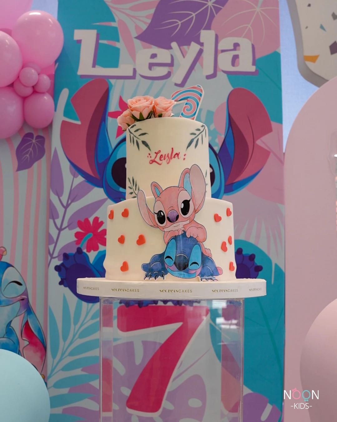 Two-tier Stitch and Angel birthday cake with pink roses.