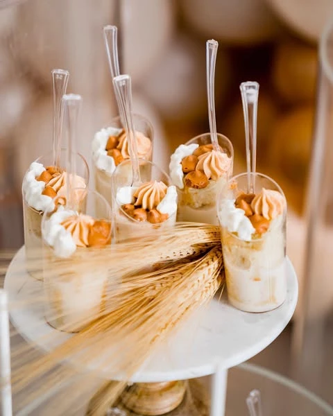 Individual dessert cups with caramel and cream toppings for a teddy bear baby shower.