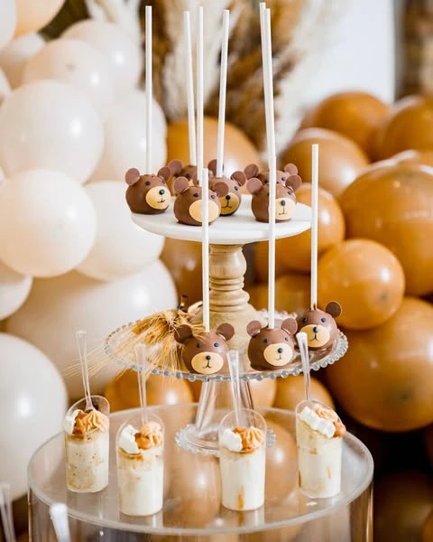 Teddy bear themed bite-sized desserts on a display stand for a baby shower.