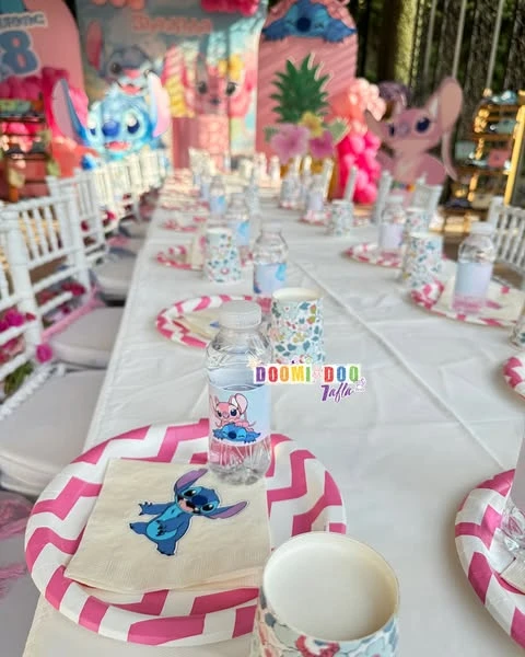 A place setting at a Stitch birthday party, featuring a pink and white chevron plate, a napkin with Stitch, and a custom water bottle.