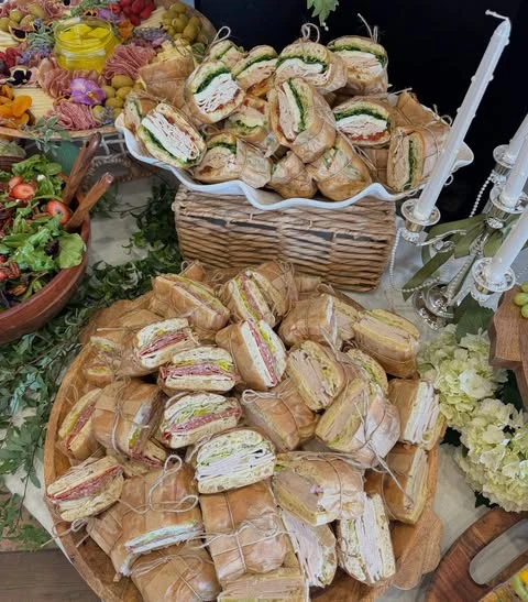 Baby shower sandwiches wrapped in parchment paper and twine.