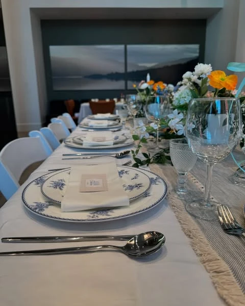 A long table set for a Peter Rabbit baby shower with repeating place settings and centerpieces.