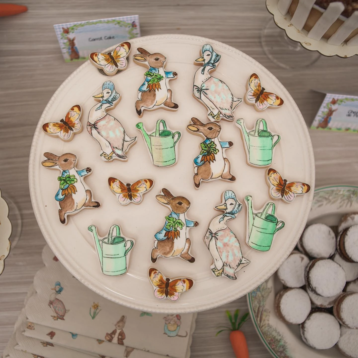 Miniature sandwiches served on a decorative cutting board with a Peter Rabbit illustration.