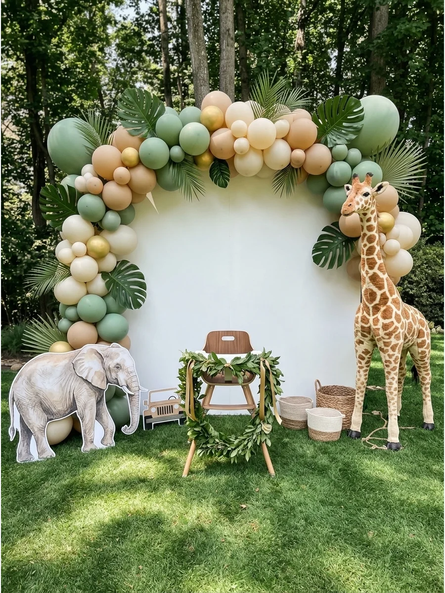Safari themed first birthday setup with green balloons and wooden accents.