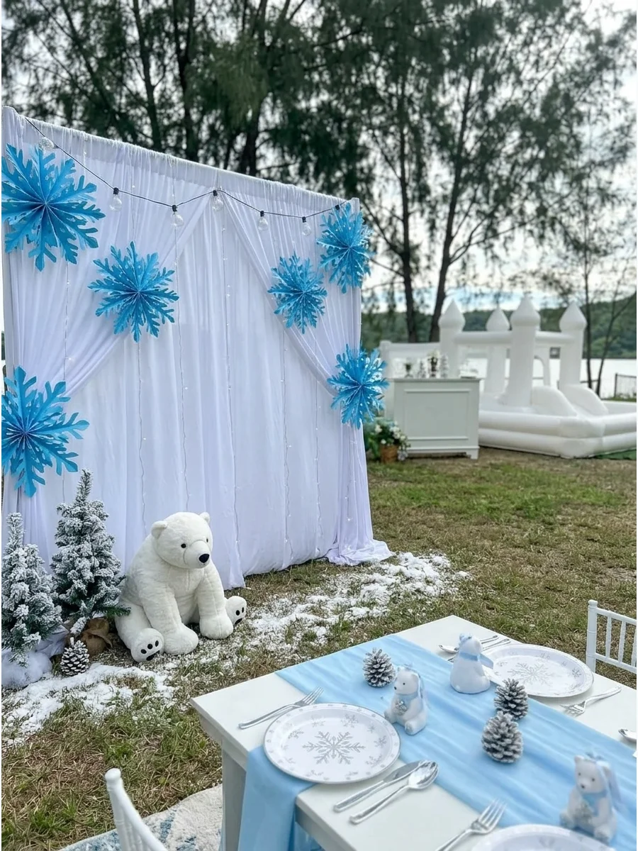 A winter themed birthday party with white and blue snowflake decorations.