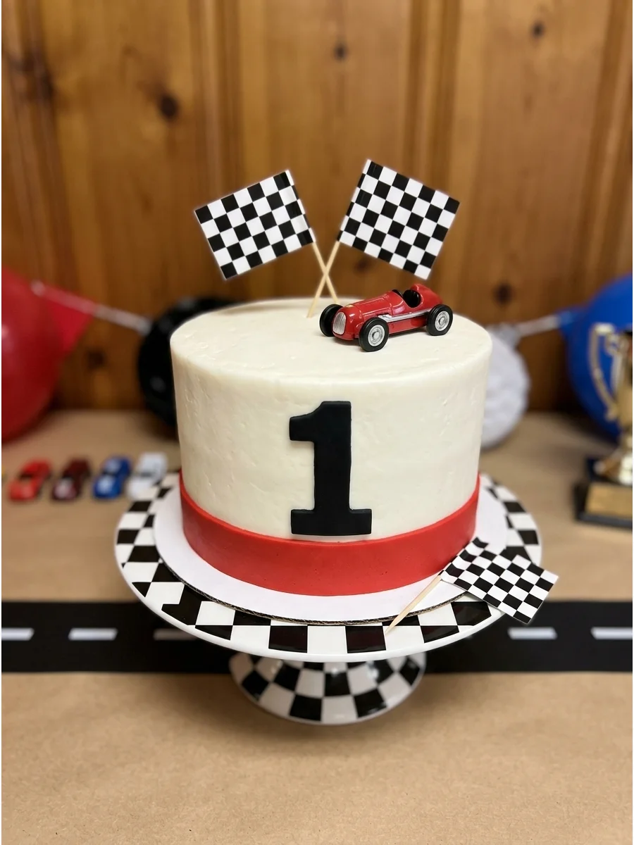 A race car birthday theme with checkered flags and red decorations.