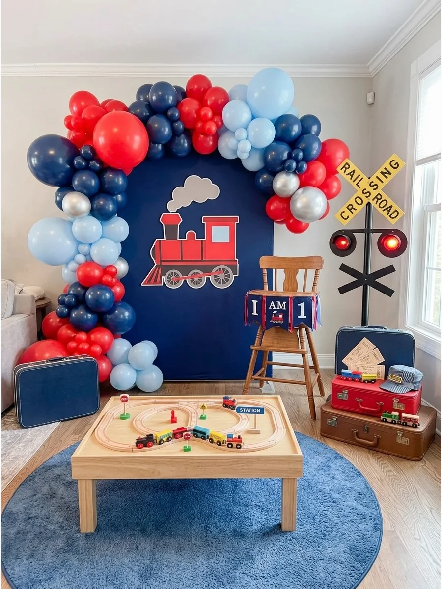 A train-themed birthday with a red engine cutout and navy blue balloons.