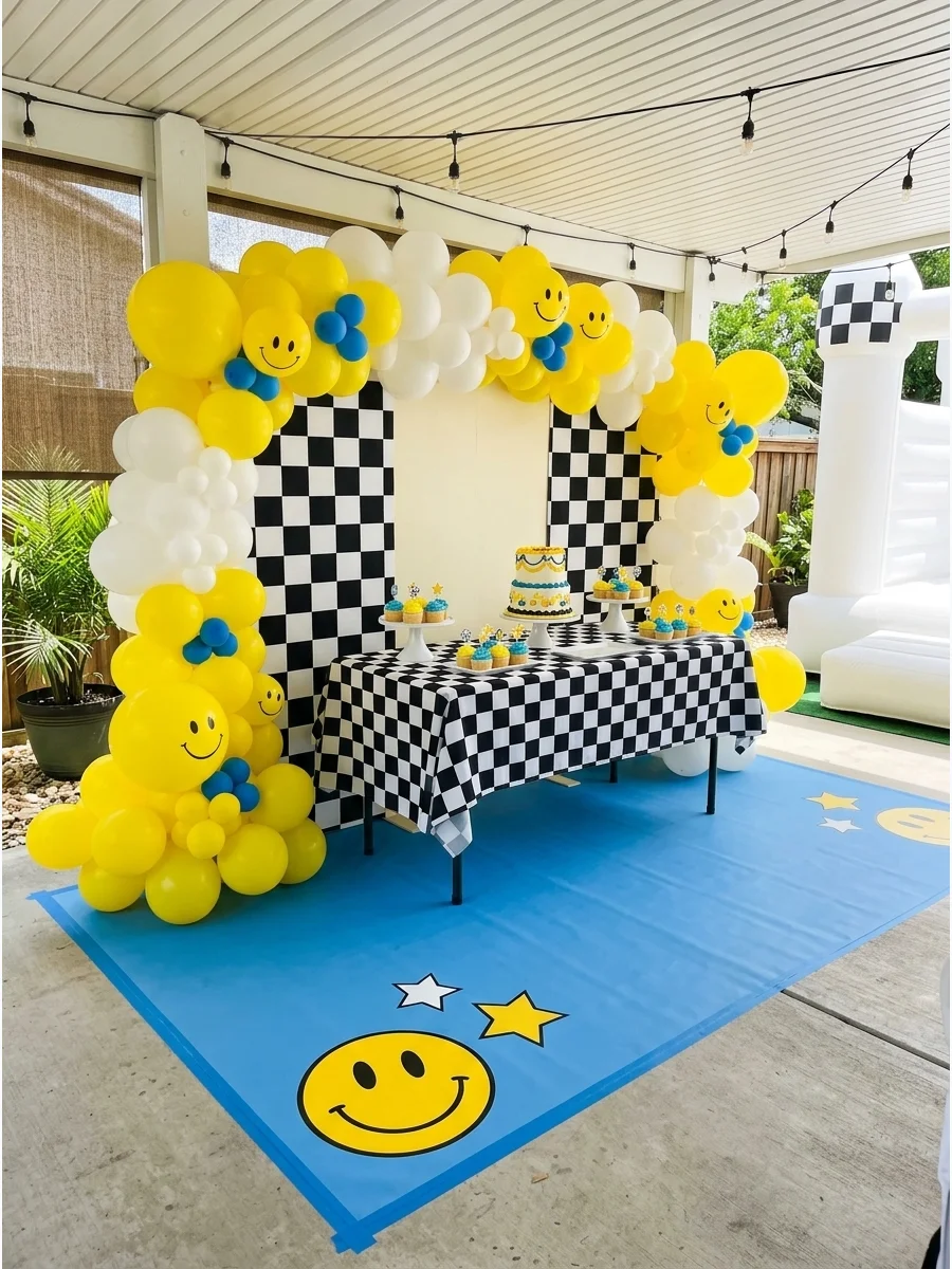 Smiley face birthday theme with yellow balloons and checkerboard patterns.