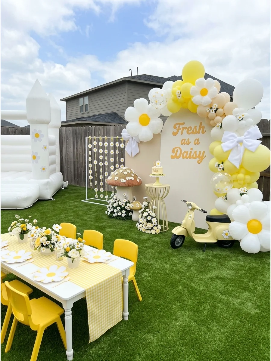 A yellow and white daisy-themed birthday table with gingham fabric.