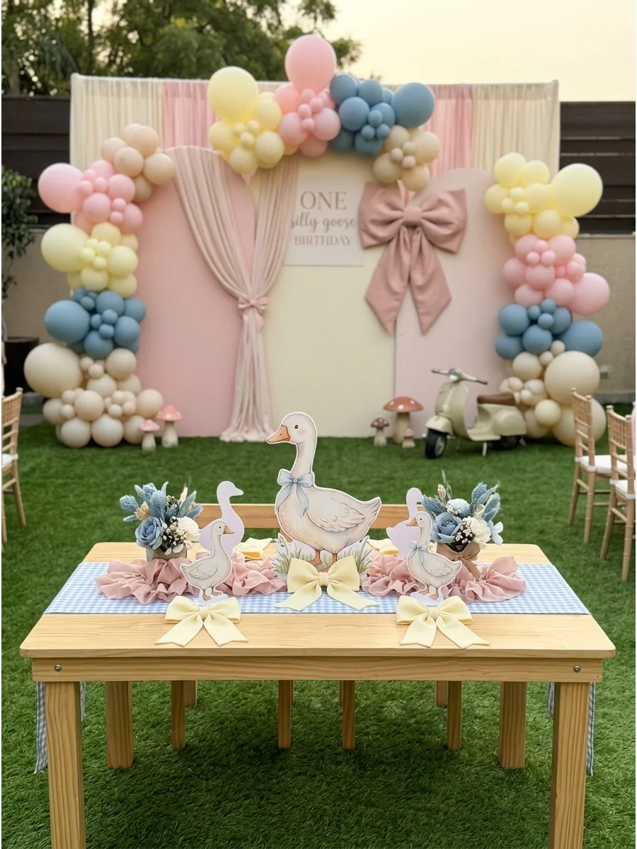 Blue gingham table runner with a pastel goose decoration.