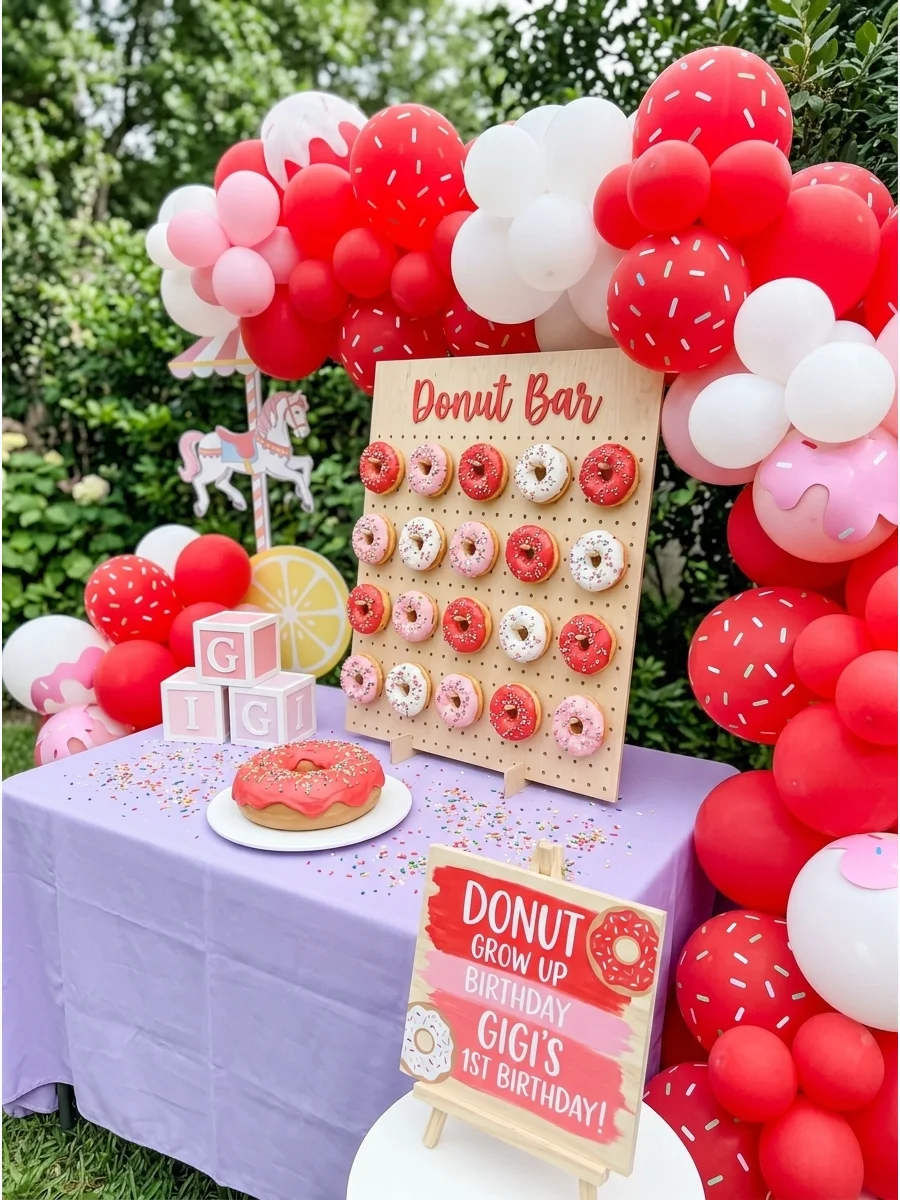 Donut themed first birthday with a pegboard display and sprinkle balloons.