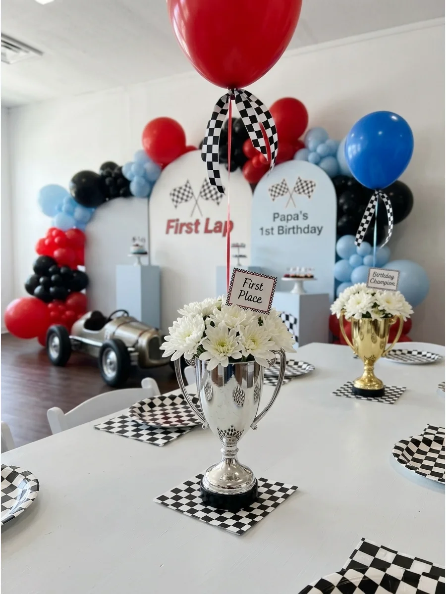 Silver trophy cup centerpiece filled with white flowers and a balloon.