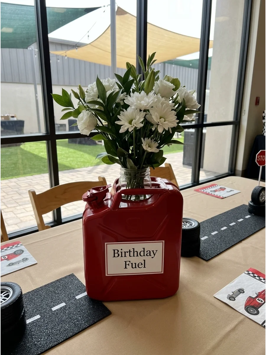 Red fuel can flower arrangement on a tan table setting.